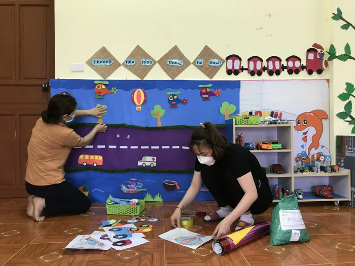 2 cô giáo lớp 5 Tuổi A1 thực hiện trang trí góc chơi bé với phương tiện giao thông